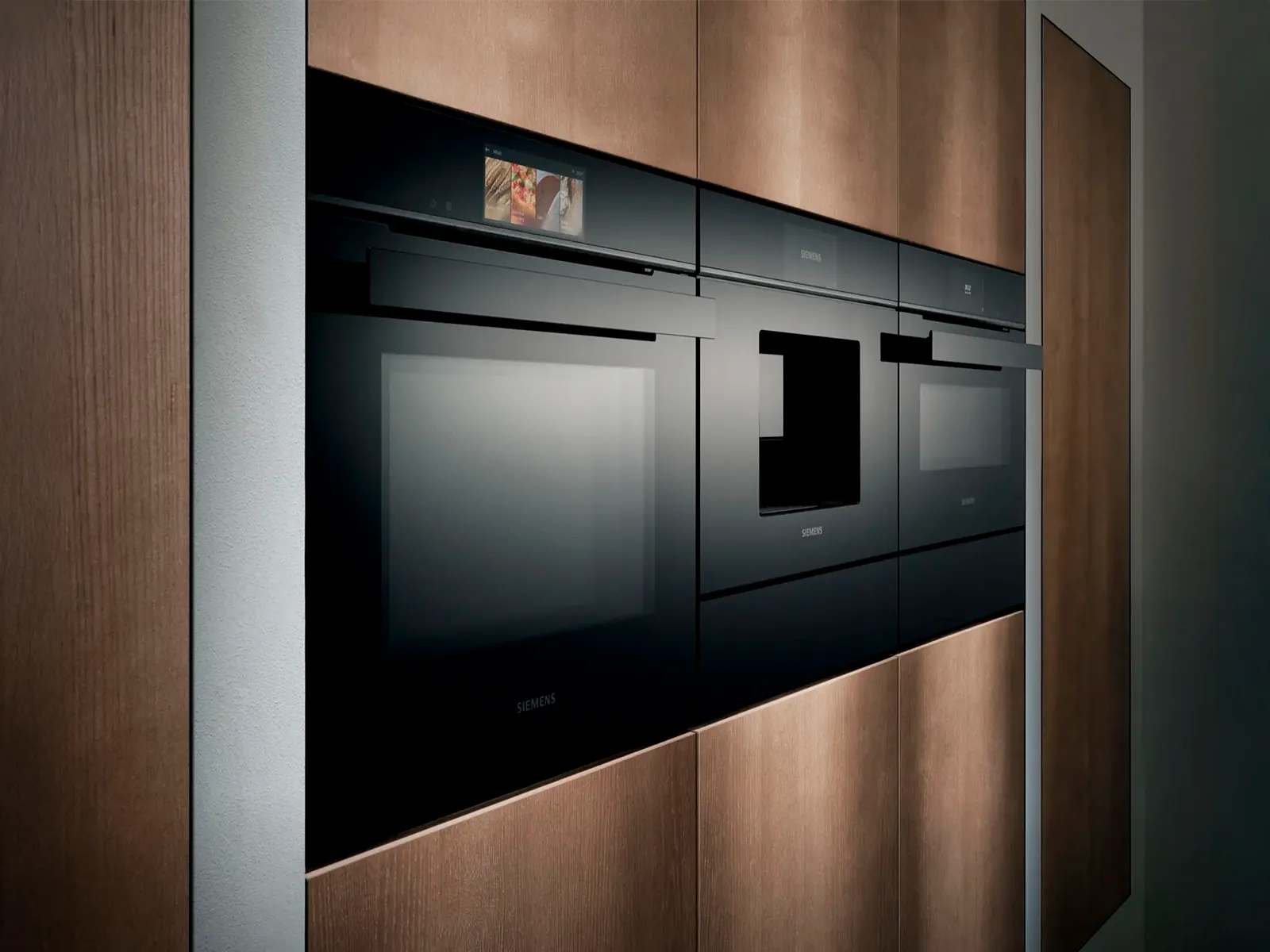 Sleek black kitchen appliances integrated into warm wooden cabinetry, featuring a modern, minimalist design.