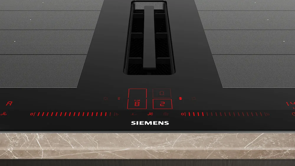 Piano cottura a induzione Siemens con comandi touch e display digitale rosso su superficie nera e bordo in marmo chiaro