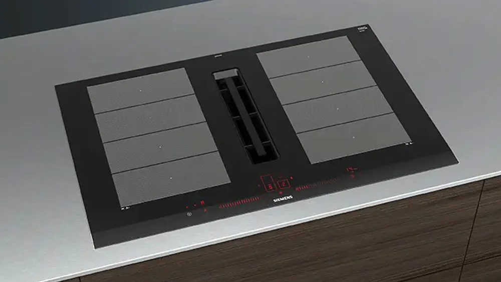 Piano cottura a induzione con cappa integrata centrale e comandi touch rossi