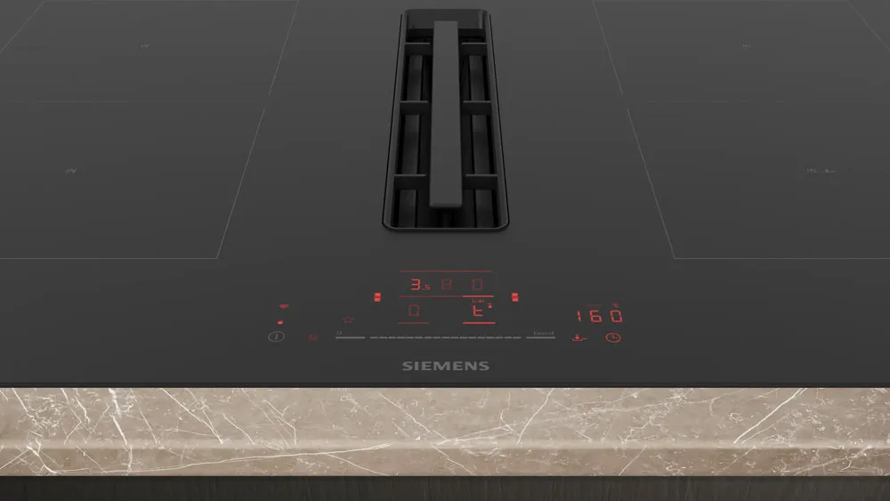 Piano cottura a induzione Siemens con display digitale rosso e griglia centrale integrata in piano marmo
