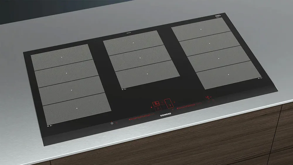 Piano cottura a induzione Siemens con tre zone di cottura rettangolari e comandi touch rossi su base nera.