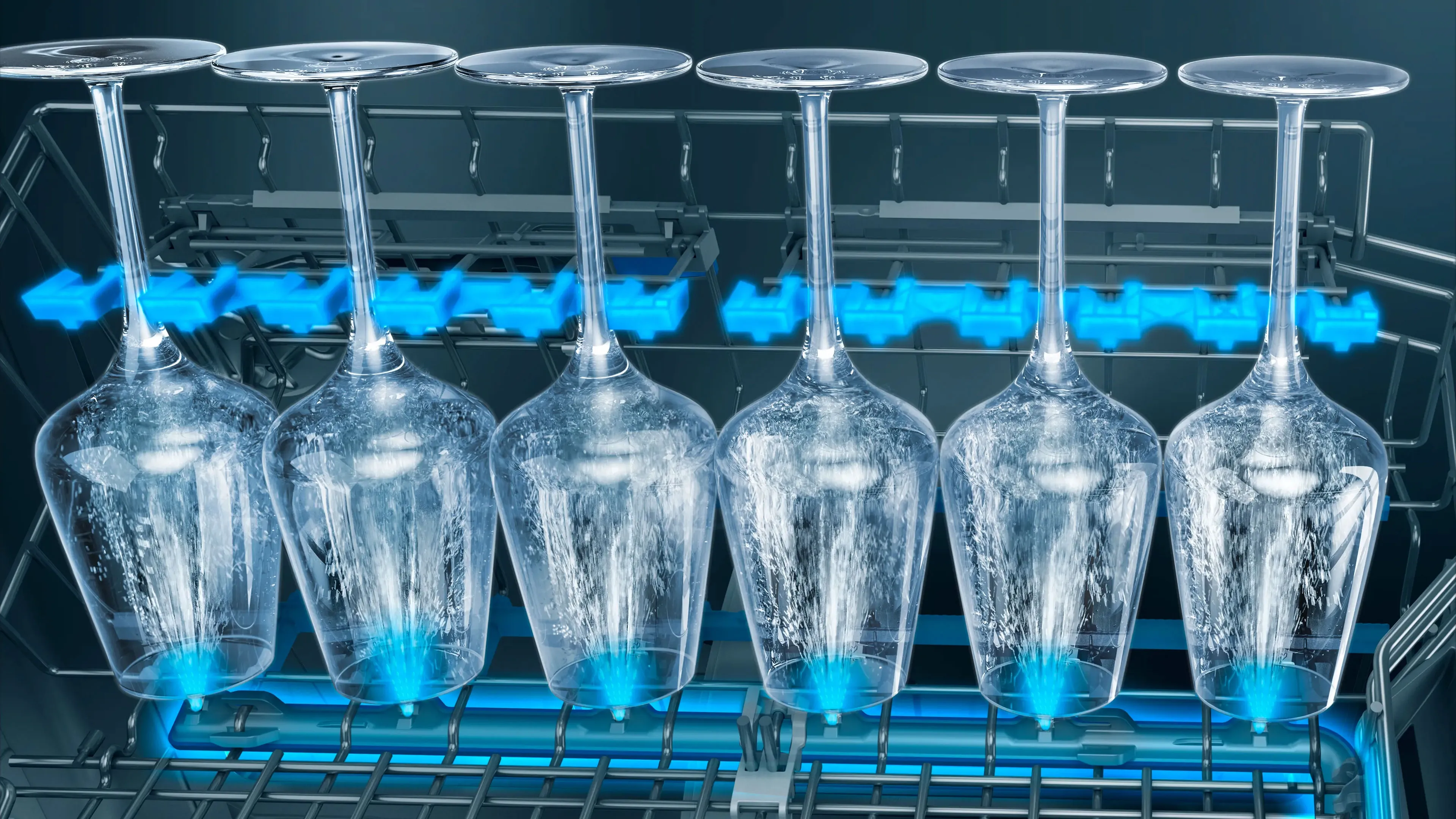Sei calici di vetro rovesciati allineati su un ripiano metallico con acqua gocciolante