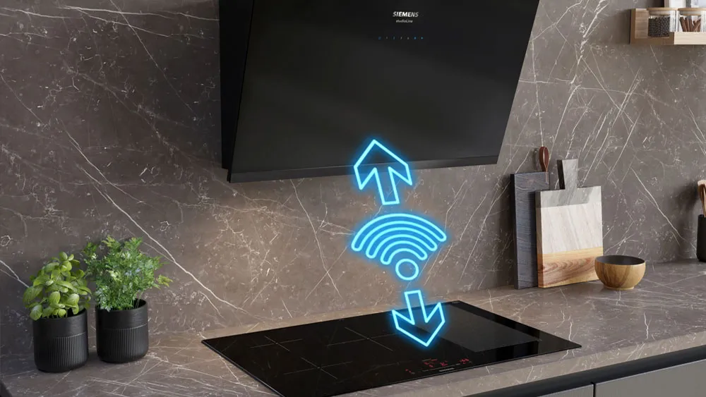 Piano cottura a induzione nero con simboli digitali blu di frecce e segnale Wi-Fi tra cappa e piano.