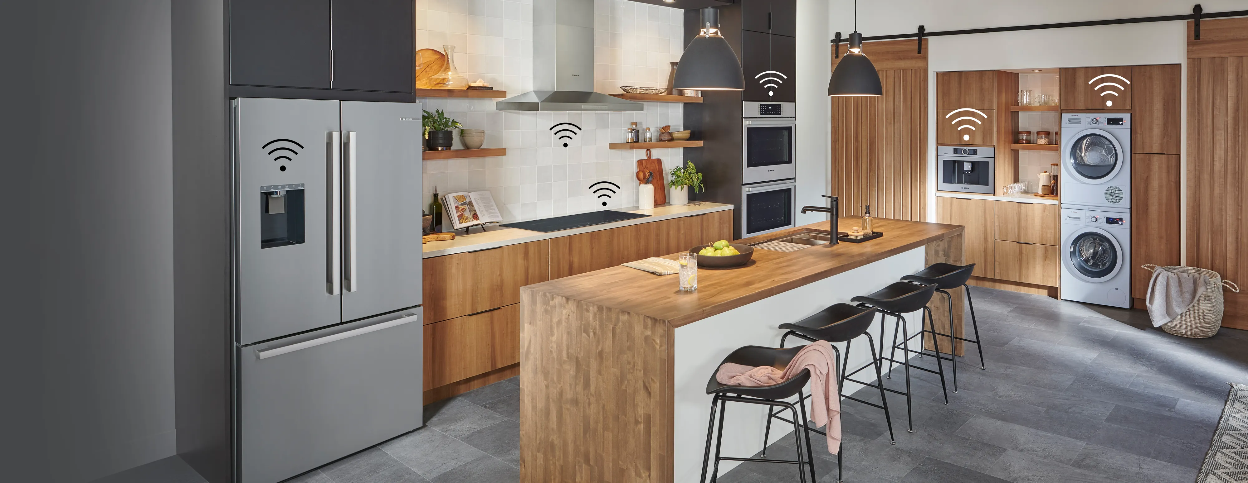 Modern kitchen with smart appliances including refrigerator, oven, stovetop, coffee maker, and washer-dryer, all connected via Wi-Fi network icons.