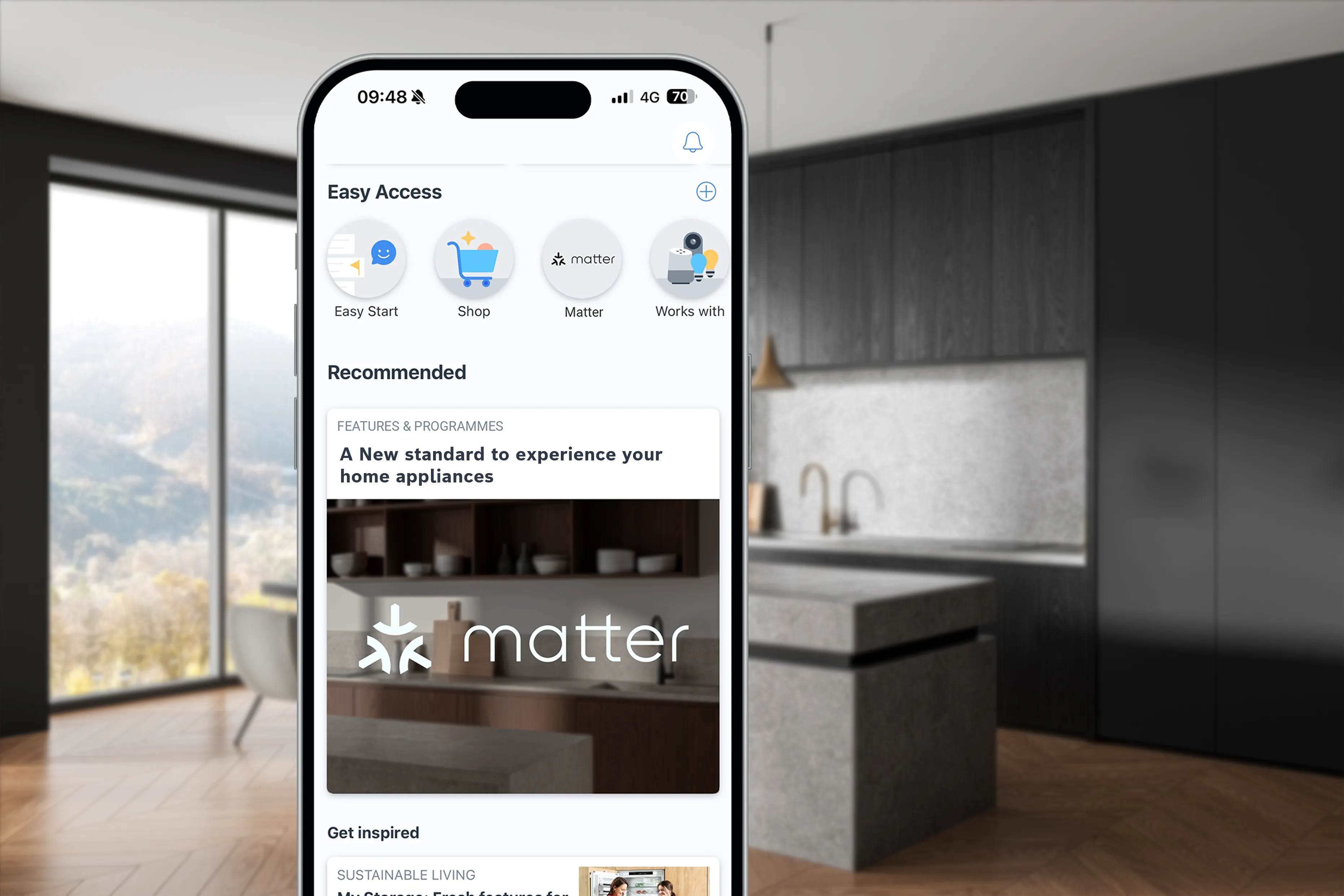 Smartphone displaying home appliance control app in a modern kitchen with dark cabinetry.