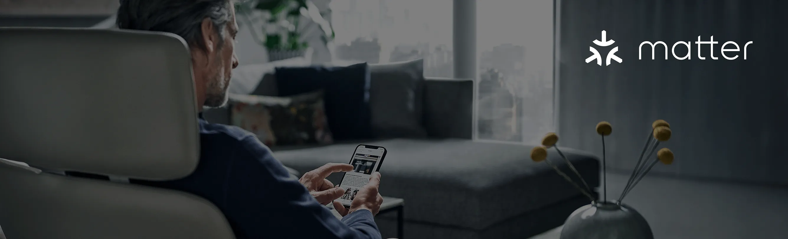 A person using a smartphone in a modern living room. The Matter logo is shown.