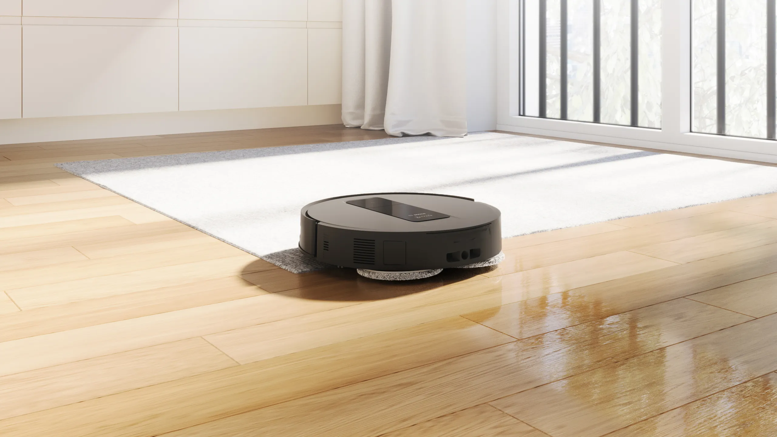 Robot aspirapolvere che pulisce il pavimento in legno vicino a un tappeto di colore chiaro in una stanza luminosa con grandi finestre.