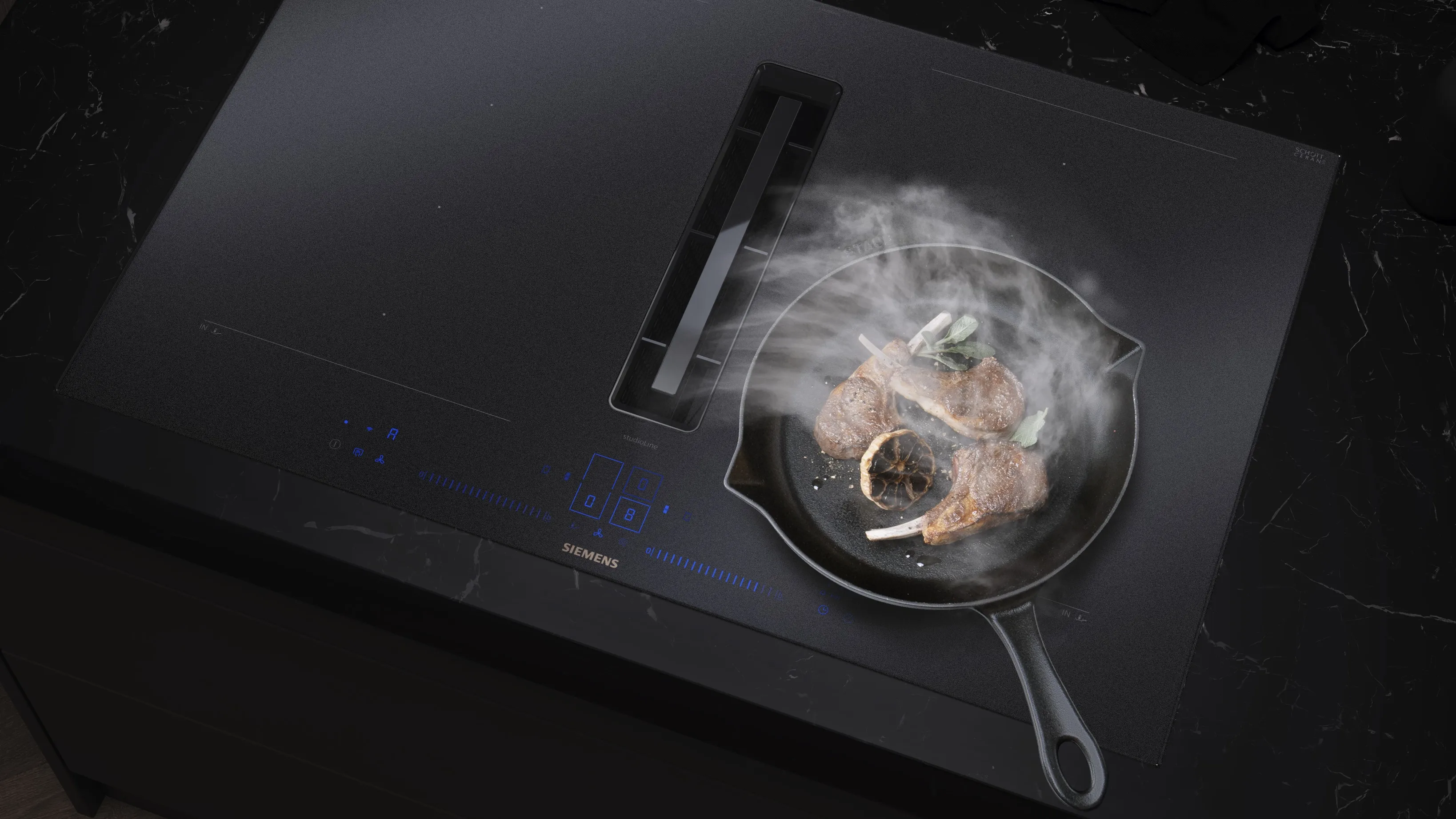 Een moderne kookplaat met een gietijzeren koekenpan met sissende steaks die rook uitstoten, tegen een slank zwart aanrecht.