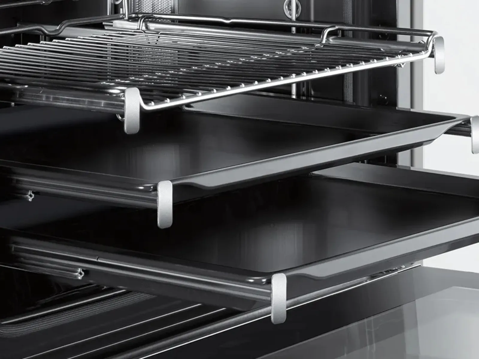 An open black oven showcasing a chrome wire rack and a sleek.