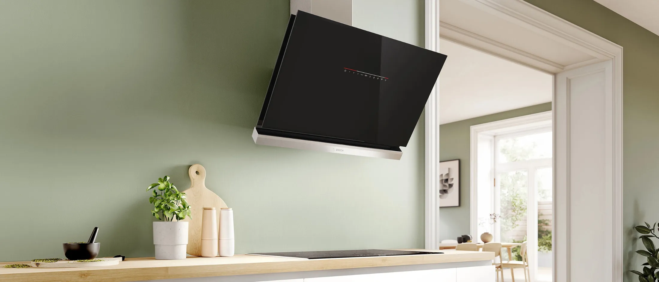 Modern kitchen with a sleek black hood, steam rising from a pan and wooden countertop.