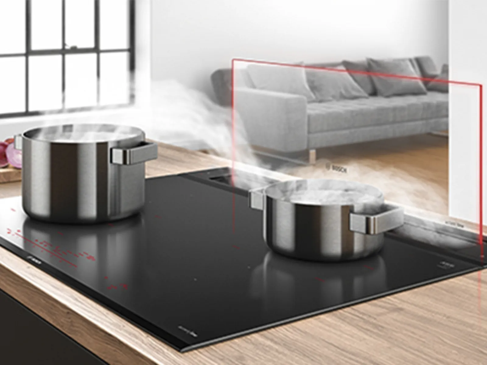 Zwei dampfende Töpfe auf einem eleganten schwarzen Bosch-Induktionskochfeld, mit einem modernen Wohnzimmer im Hintergrund sichtbar.