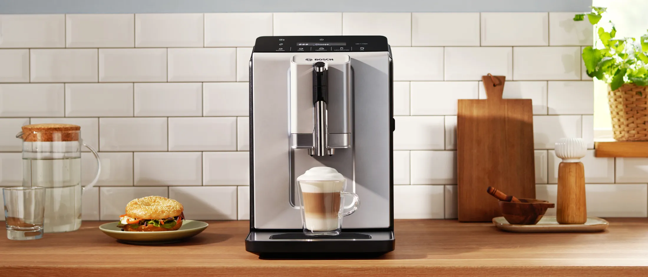 Kavni aparat Vero Café Serie 2 s cappuccinom na kuhinjskem pultu.