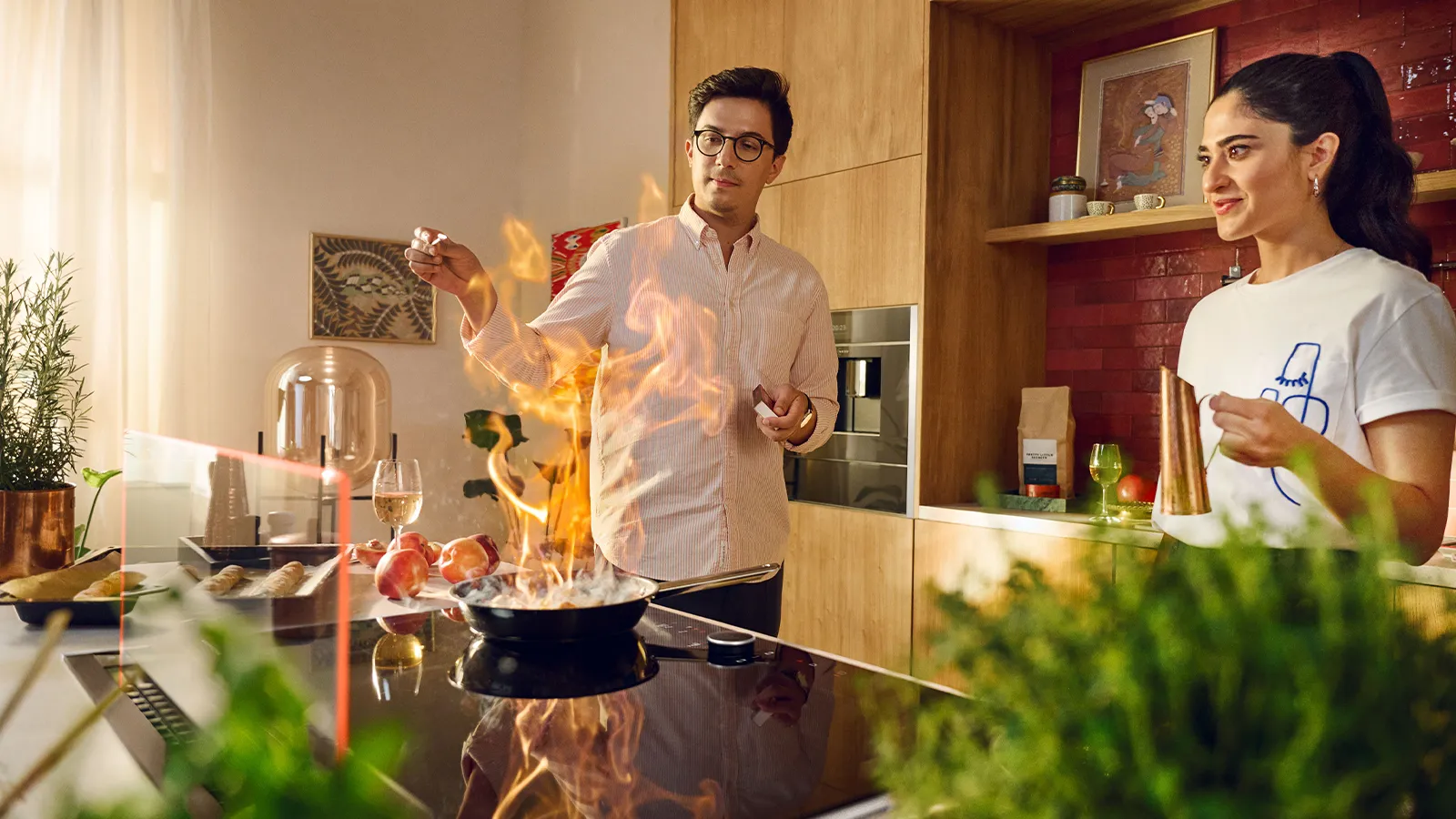 A diverse group of people cooking in a kitchen featuring a glass draft hood, engaged in meal preparation and teamwork.  