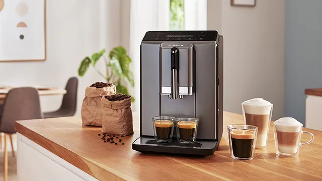 En elegant kaffemaskin på en träbänkskiva som brygger espresso och cappuccino.