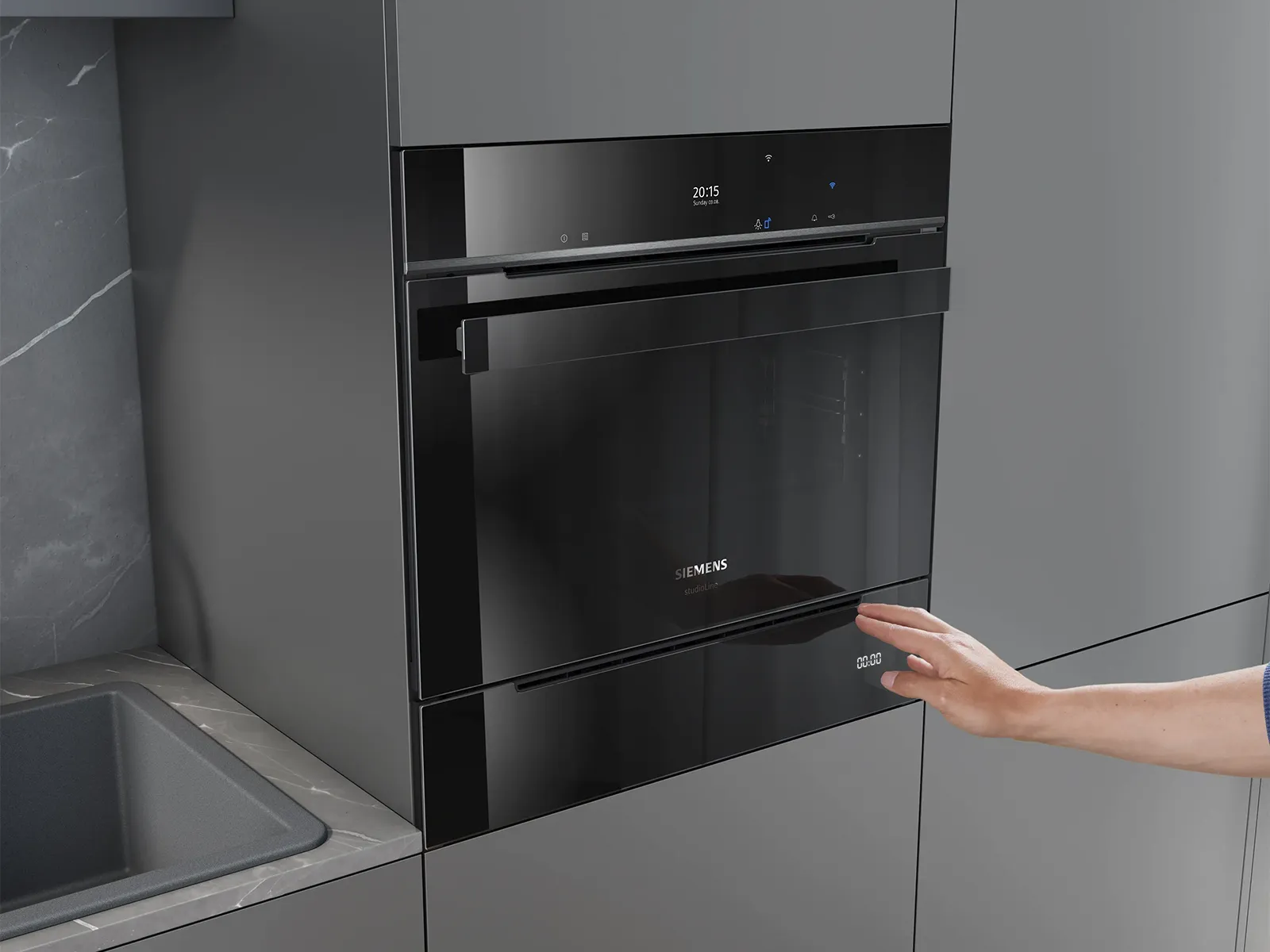 Un forno integrato Siemens in una cucina moderna, con una mano che si avvicina per aprirlo.