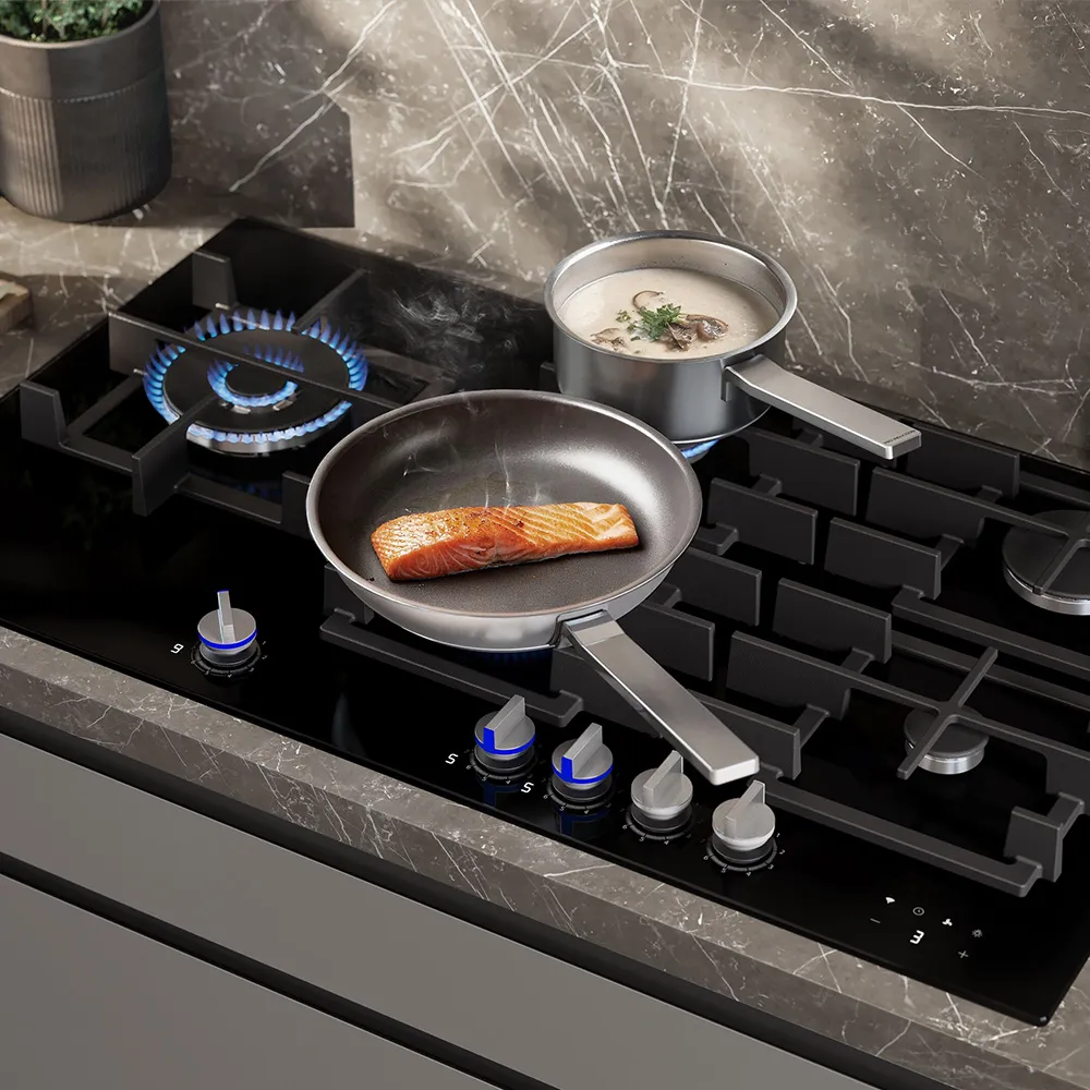 A sleek kitchen stove with a pan frying food and a pot steaming on the side, surrounded by modern appliances and a stylish surface.