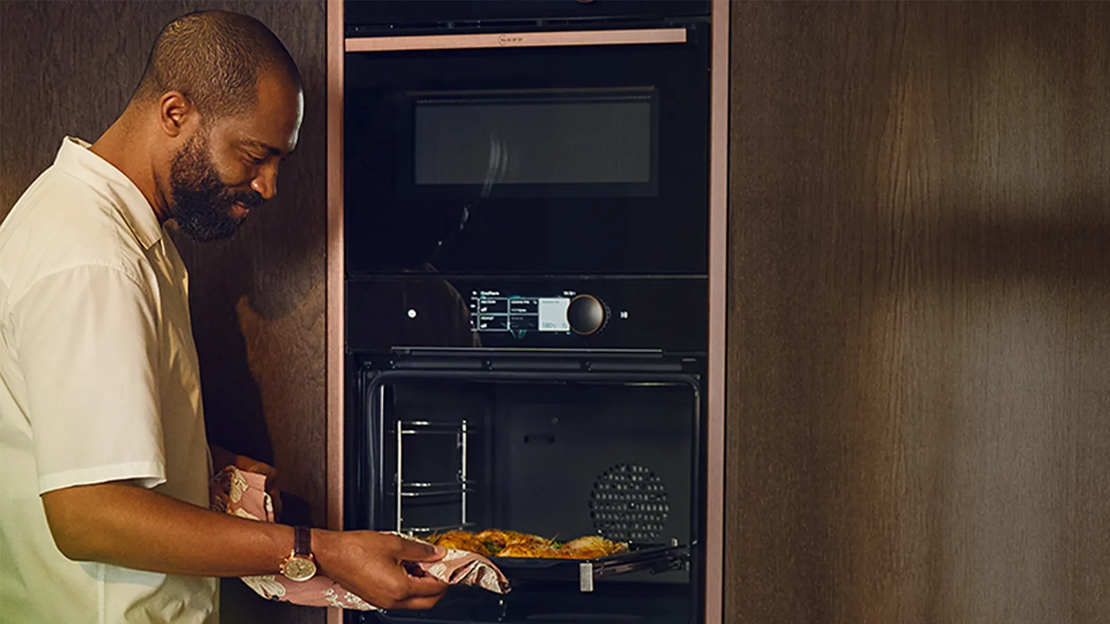 Man taking tray out of oven