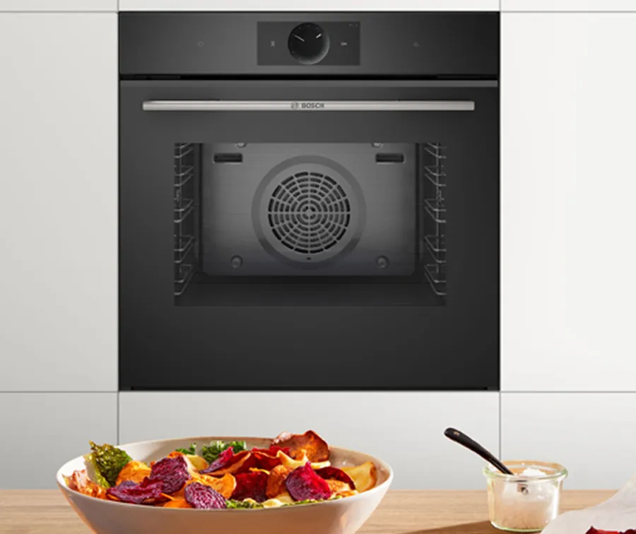Kitchen counter with veg in bowl, steam oven in background.