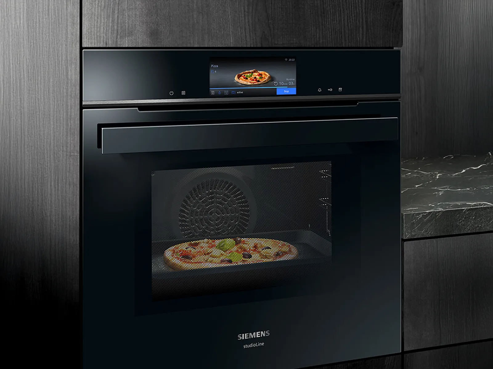 En sort Siemens ovn med digitalt display bager en pizza