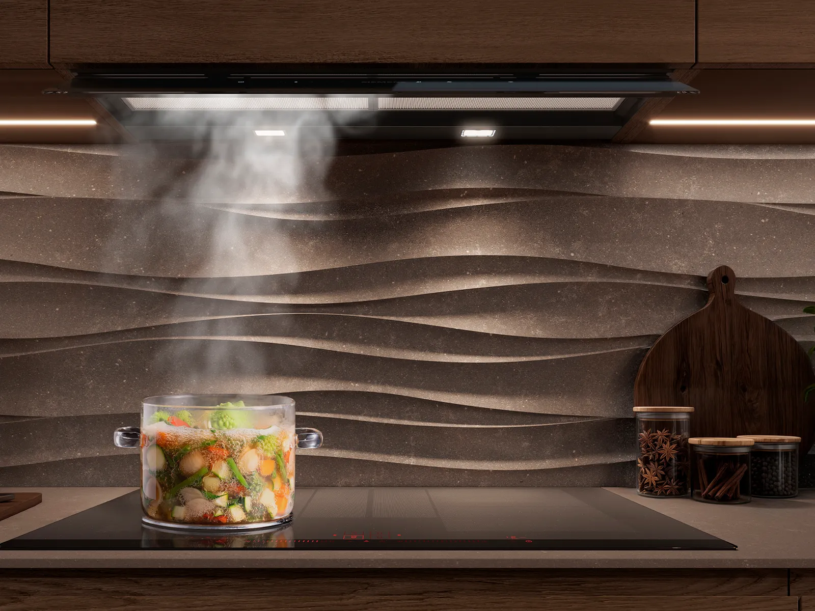 Moderne Küche mit einem Glas Topf Gemüse, der auf einem Induktionskochfeld unter einer Dunstabzugshaube dampft.