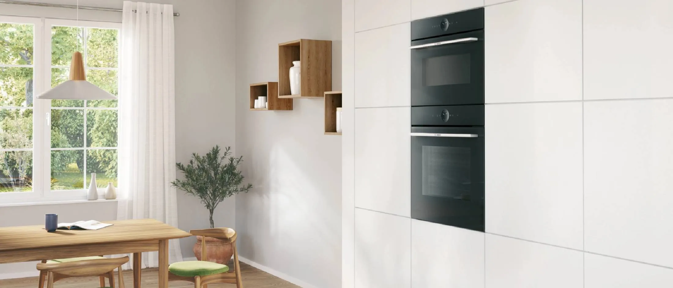 Il forno a microonde Bosch integrato si integra perfettamente sulla parte superiore di un forno in una moderna cucina bianca e legno.