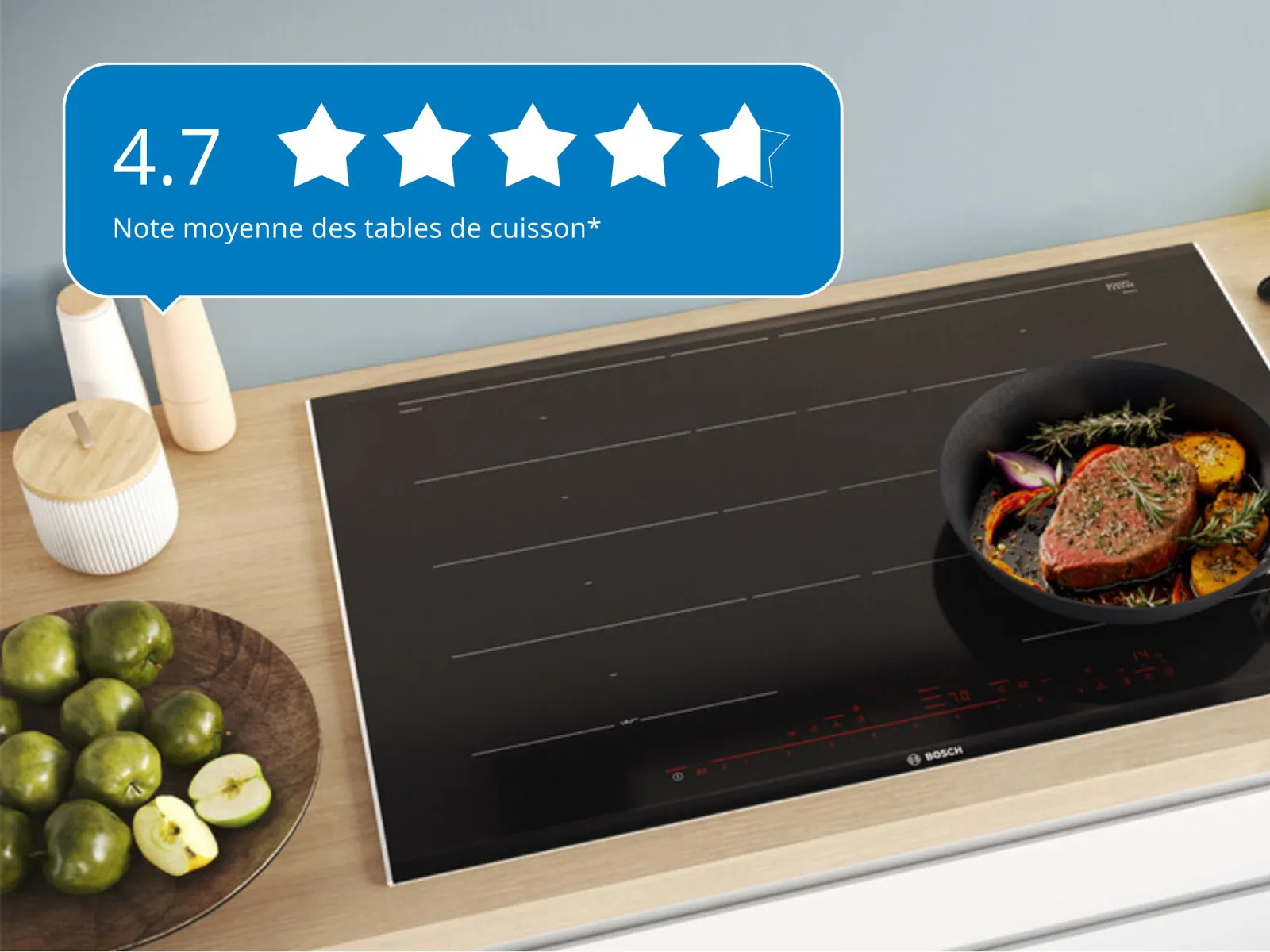 Une table de cuisson à induction moderne présentant une poêle avec un steak et des légumes cuits, à côté d'un bol de citrons verts, avec une note de 4,7 étoiles.
