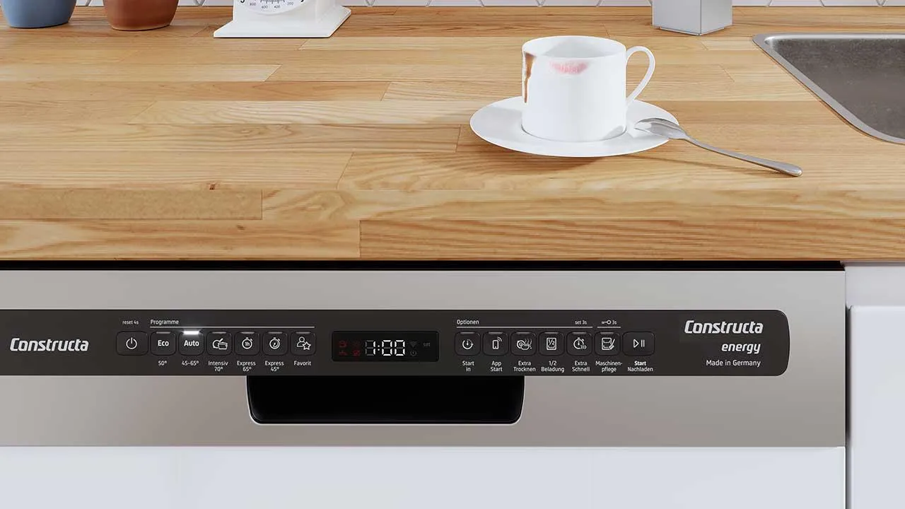 Bedienfeld eines Constructa Geschirrspülers mit verschiedenen Programmen. Benutzte Tasse auf der Arbeitsplatte.