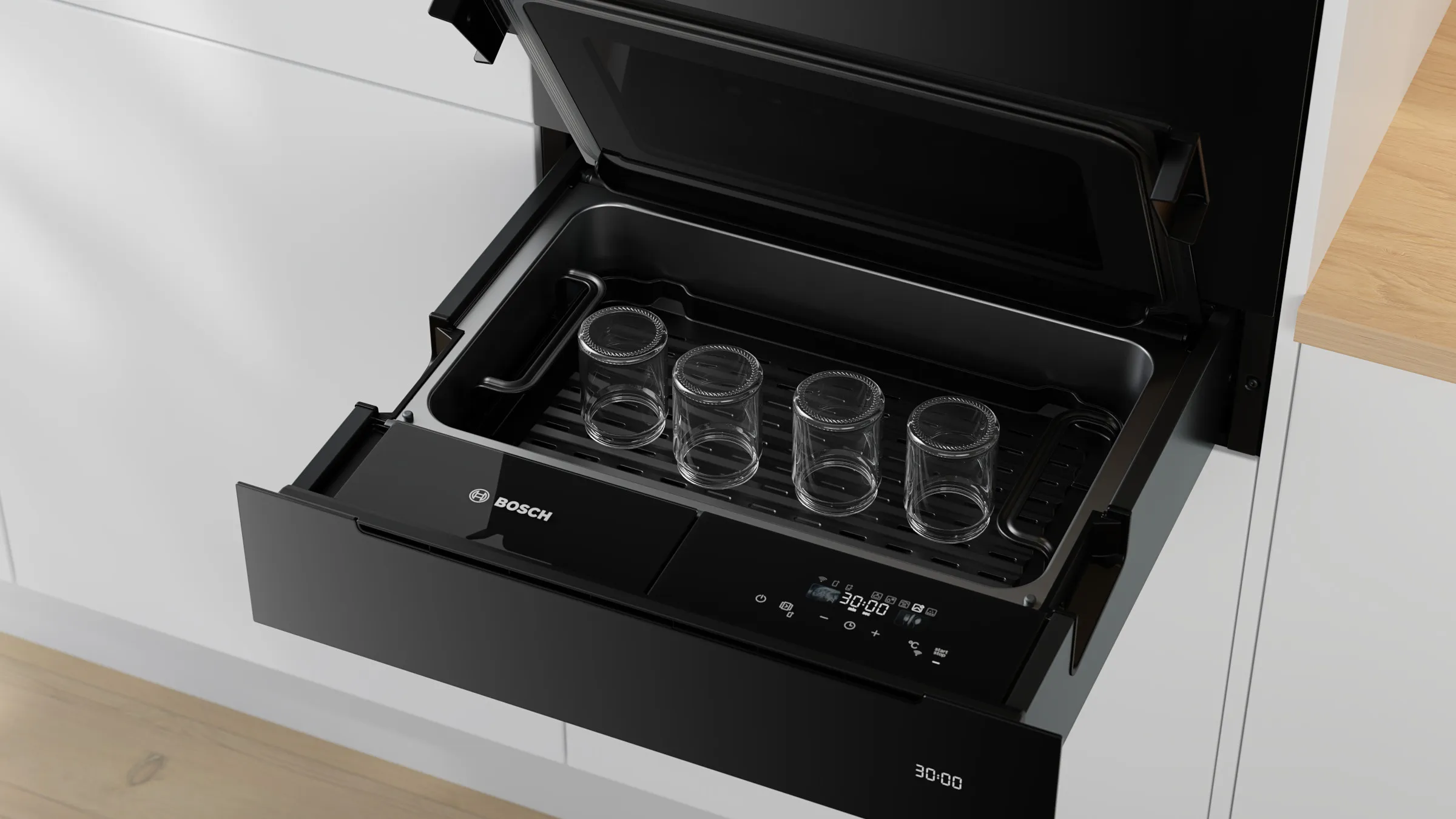 Nahaufnahme der geöffneten Bosch Serie 8 Dampfgarer-Schublade mit vier leeren Einmachgläsern zum Sterilisieren im Inneren.