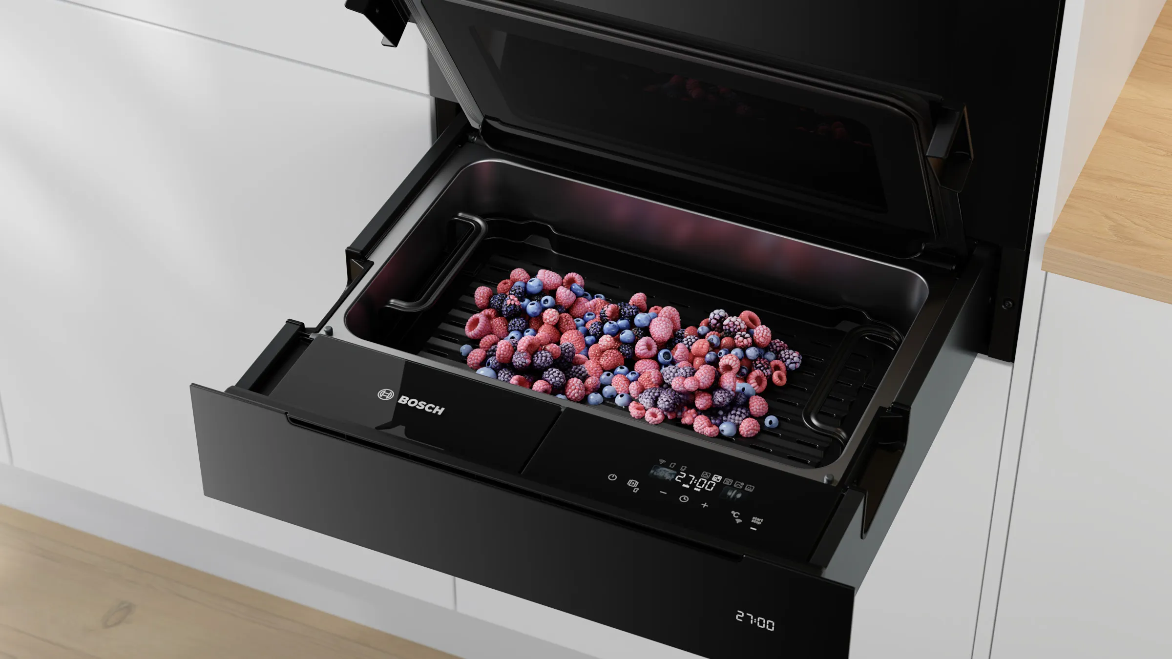 Nahaufnahme der geöffneten Bosch Serie 8 Dampfgarer-Schublade mit einer bunten Beerenmischung (Himbeeren und Blaubeeren) zum Auftauen im Inneren.