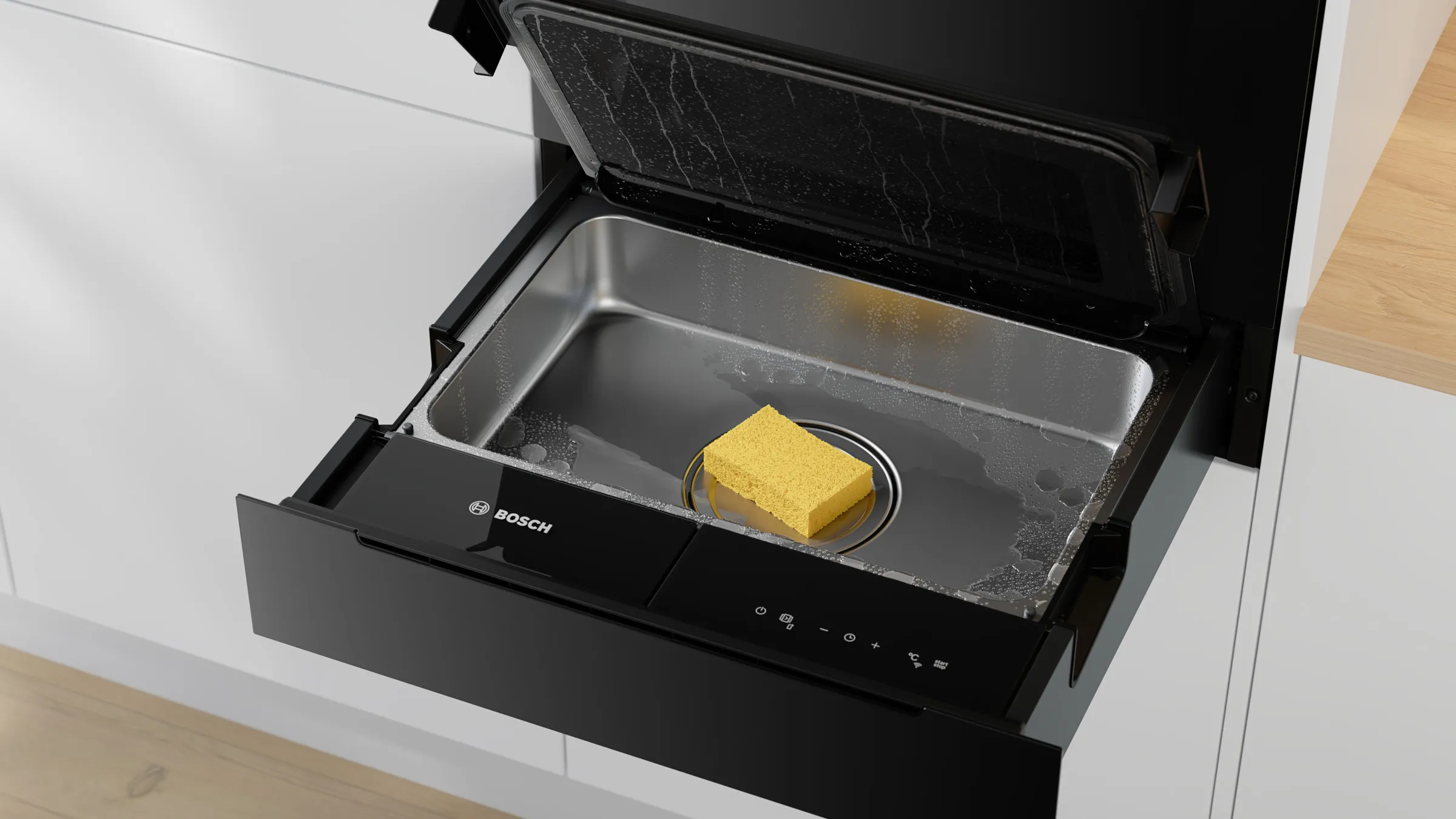 Nahaufnahme der geöffneten Bosch Serie 8 Dampfgarer-Schublade mit einem gelben Schwamm auf dem Ablauf im feuchten Innenraum.