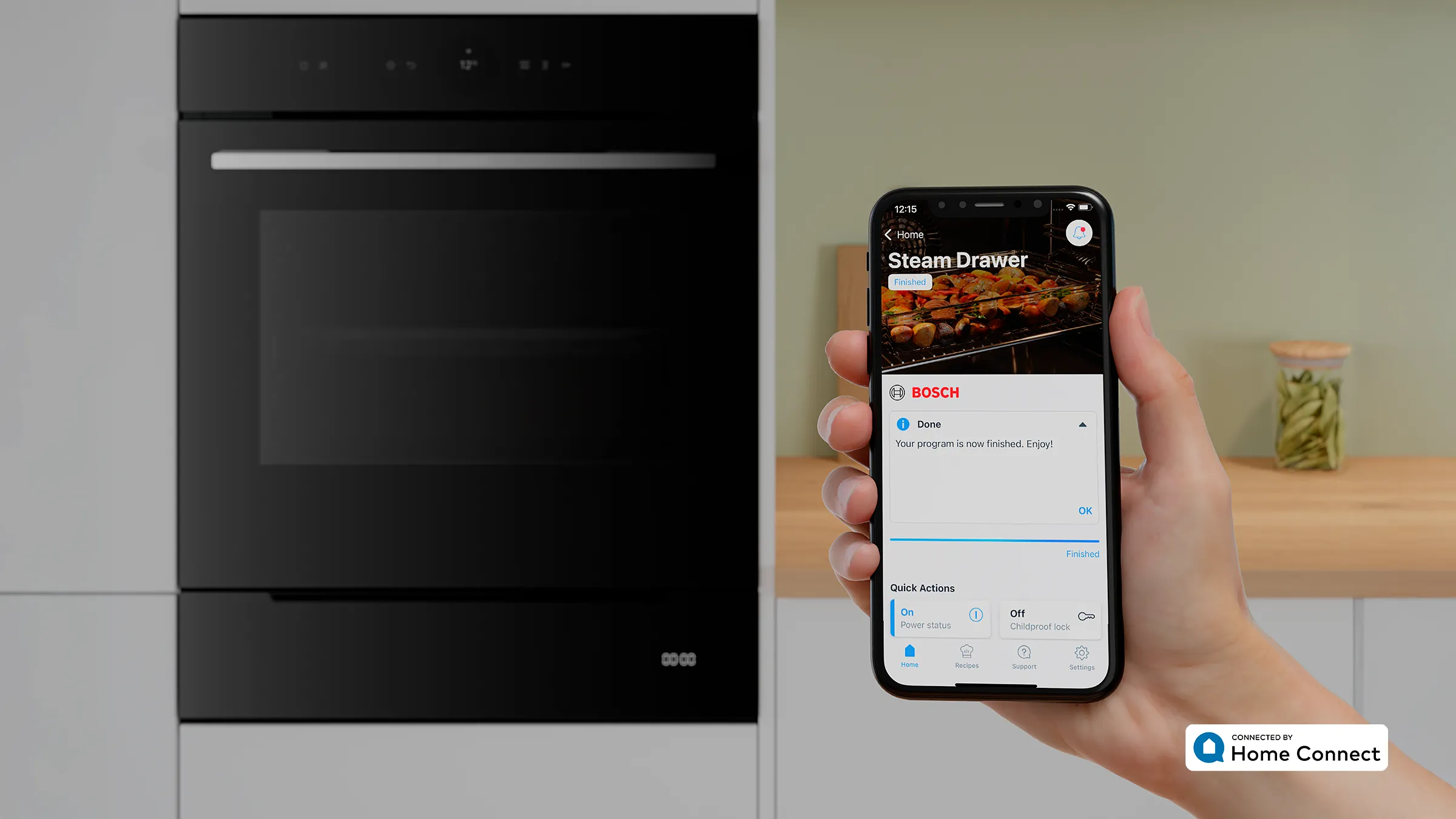 Eine Hand hält ein Smartphone mit der geöffneten Home Connect App vor einem Bosch Serie 8 Backofen, um den Status der Dampfgarer-Schublade anzuzeigen.