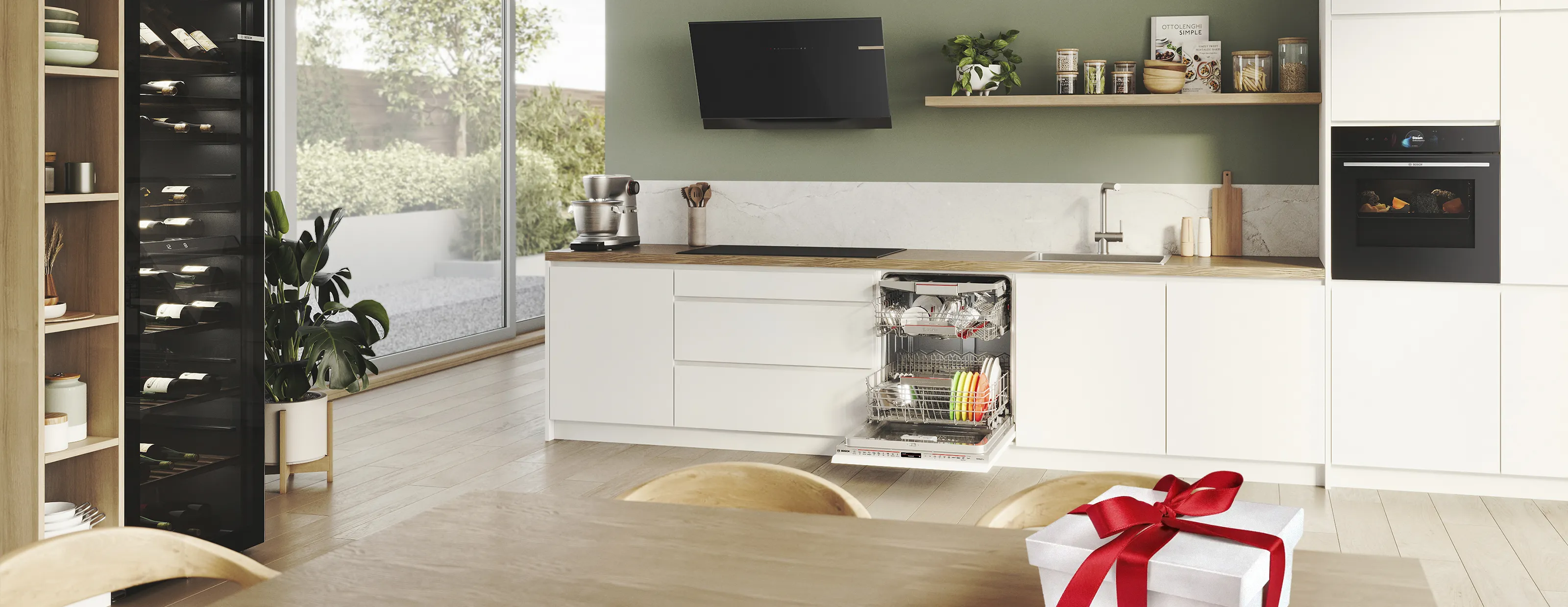 Moderne keuken met wijnkoeler, open vaatwasser en een geschenkdoos op tafel, met veel natuurlijk licht.