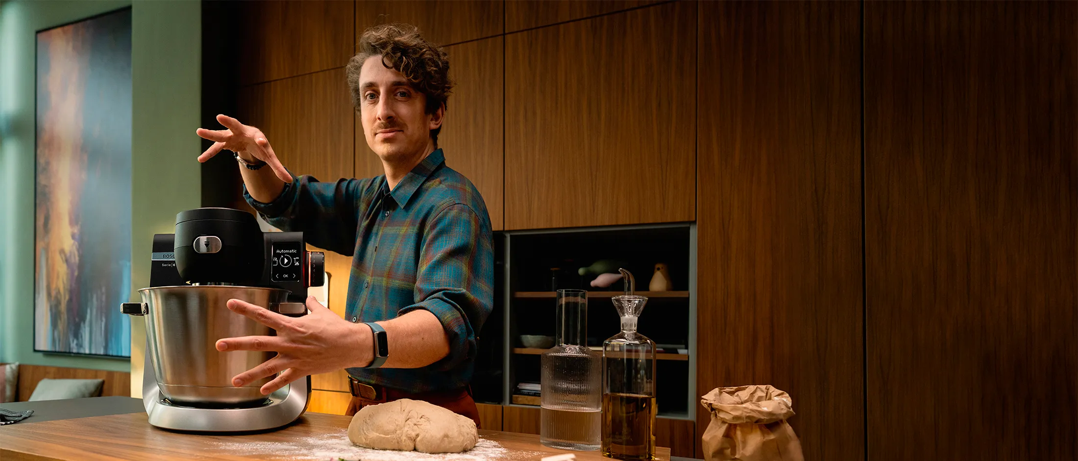 Machine de cuisine Series 6 sur un plan de travail, avec un homme qui fait un geste magique de la main.