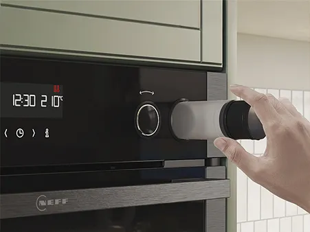 NEFF Dampferweiterung B5AVM7AG7 und Hand, die eine Wasserflasche herausnimmt.