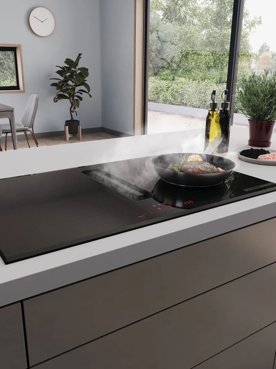 Plaque de cuisson aspirante avec poêle remplie d'aliments qui cuisent