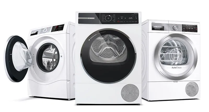 Three white Bosch front-loading washing machines, with one on the left having its door open.