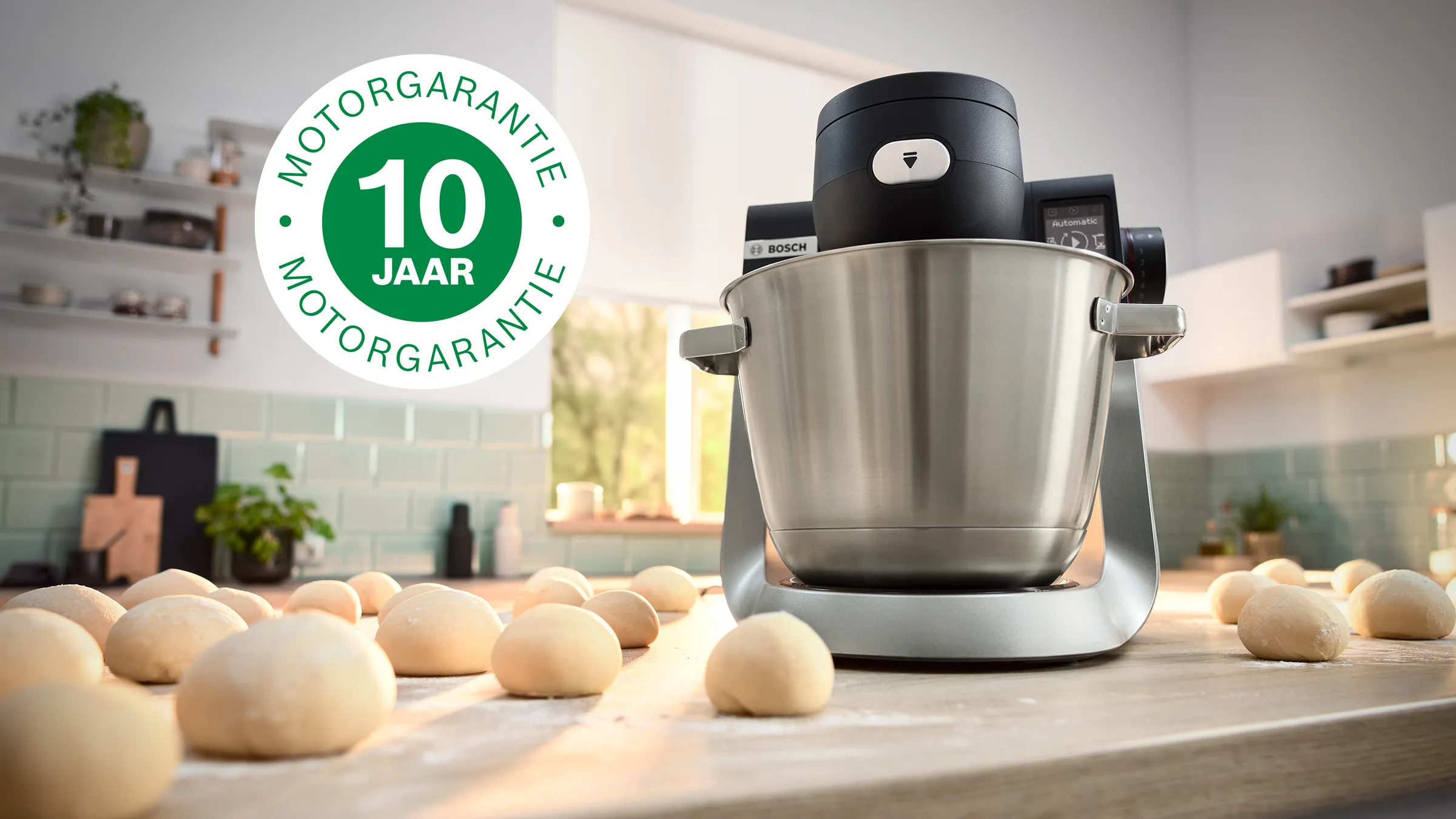 Afbeelding toont de Series 6 standmixer op het aanrecht naast verschillende deegballen en met daarop het logo van 10 jaar garantie.