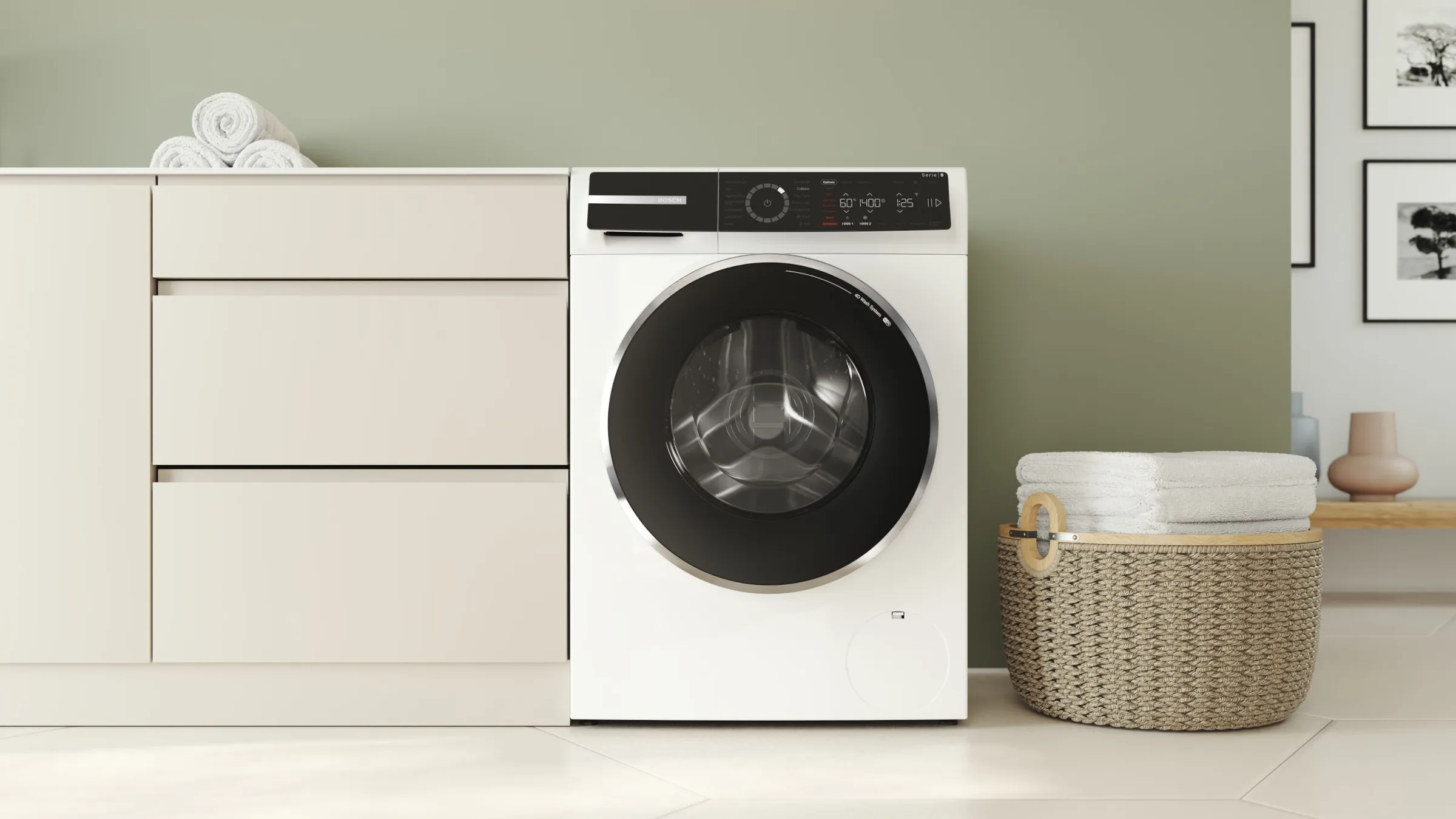 Eine moderne, weiße Bosch Waschmaschine eingebaut neben einer hellen Kommode vor einer salbeigrünen Wand.