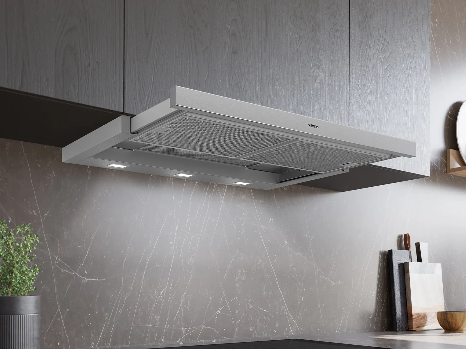 A sleek, modern Siemens kitchen hood installed beneath wooden cabinets, with smoke rising and LED lights illuminating the area below.