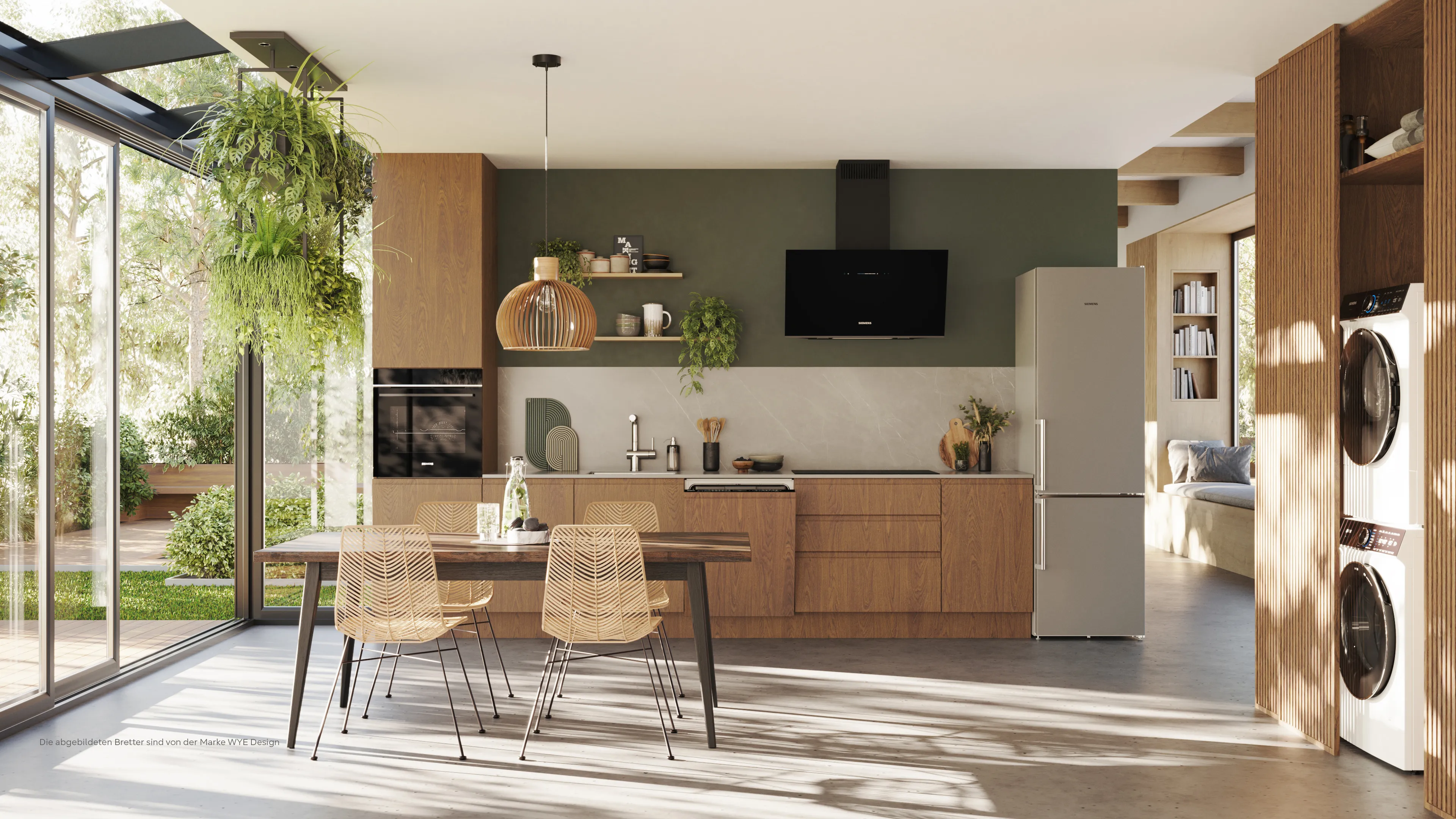 A modern open-plan kitchen and dining area with wooden cabinets, a green accent wall, Siemens appliances, and large glass doors opening to a garden.