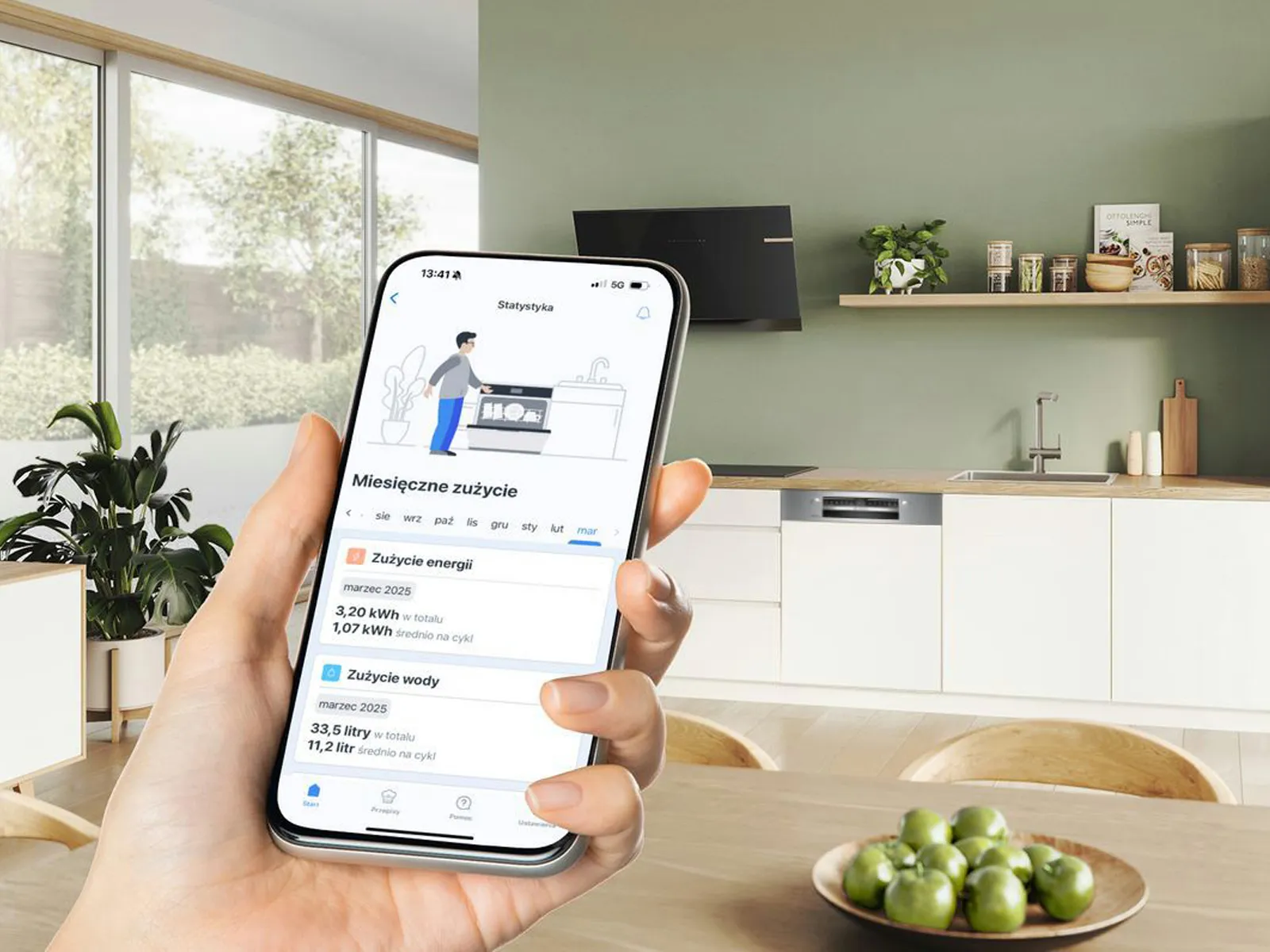 Dłoń trzymająca smartfon. Nowoczesna kuchnia w tle. 