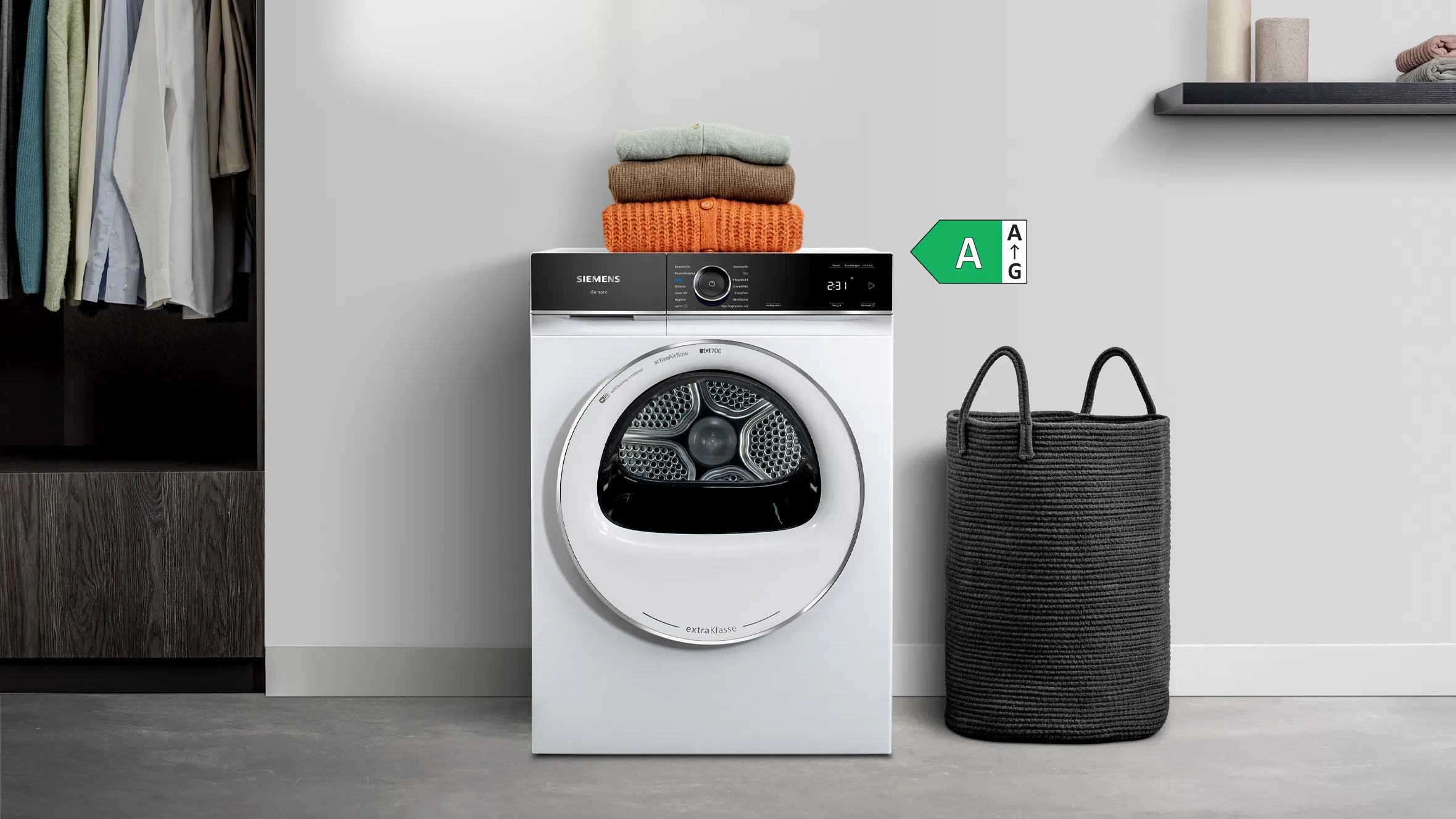 Siemens iQ700 extraKlasse Trockner mit Wäschekorb und gefalteten Pullovern – modernes Design und energieeffiziente Wäschepflege.