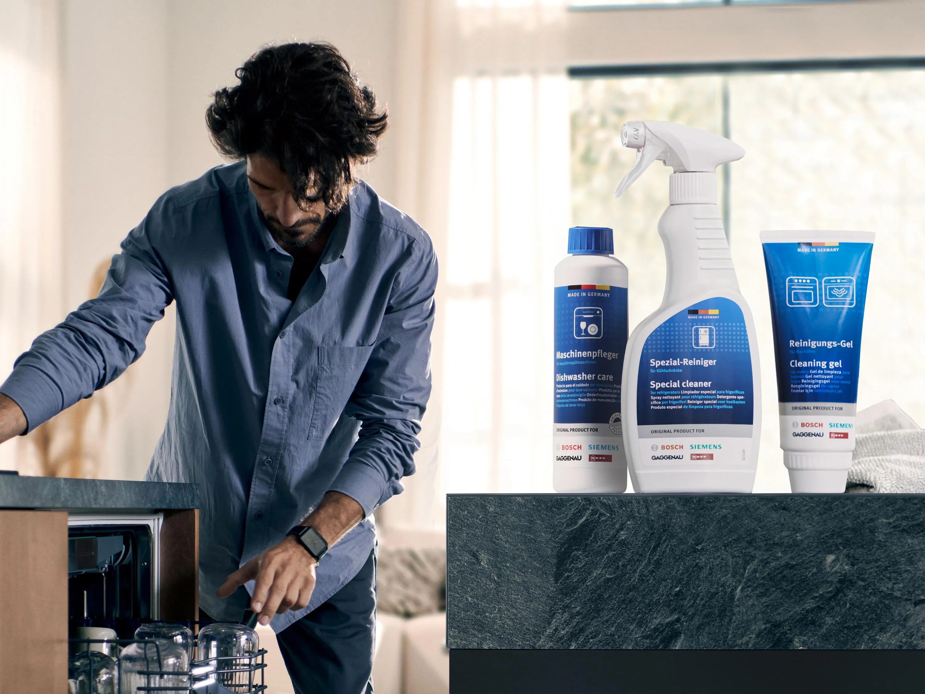 alt-Męzczyzna czyści zmywarkę Siemens w kuchni, obok stoją środki do czyszczenia i pielęgnacji.