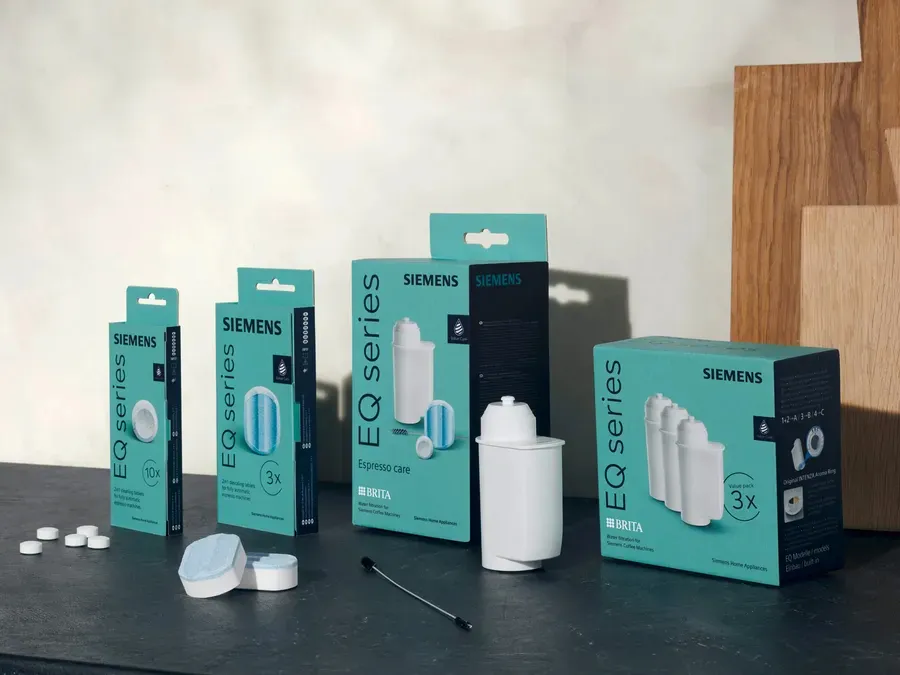 Boxes of various household appliances and products on a dark surface.