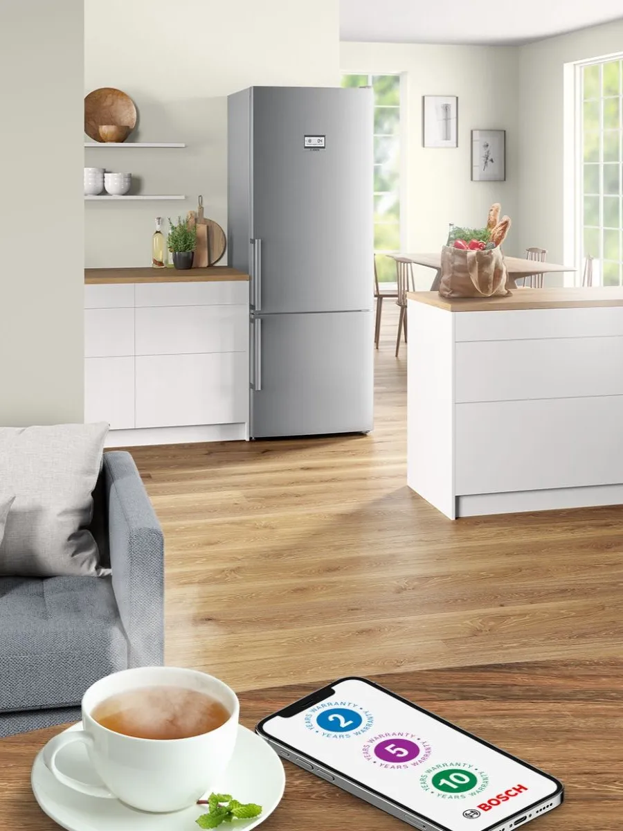Light open kitchen and living area with mobile showing Bosch 2, 5 and 10 year warranty icons