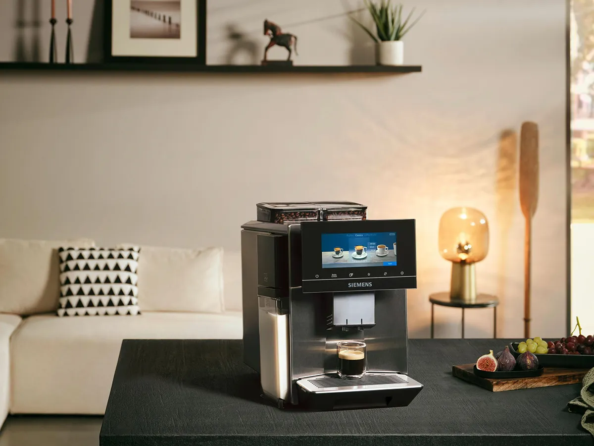 Ekspres Siemens na blacie w kuchni w tle sofa