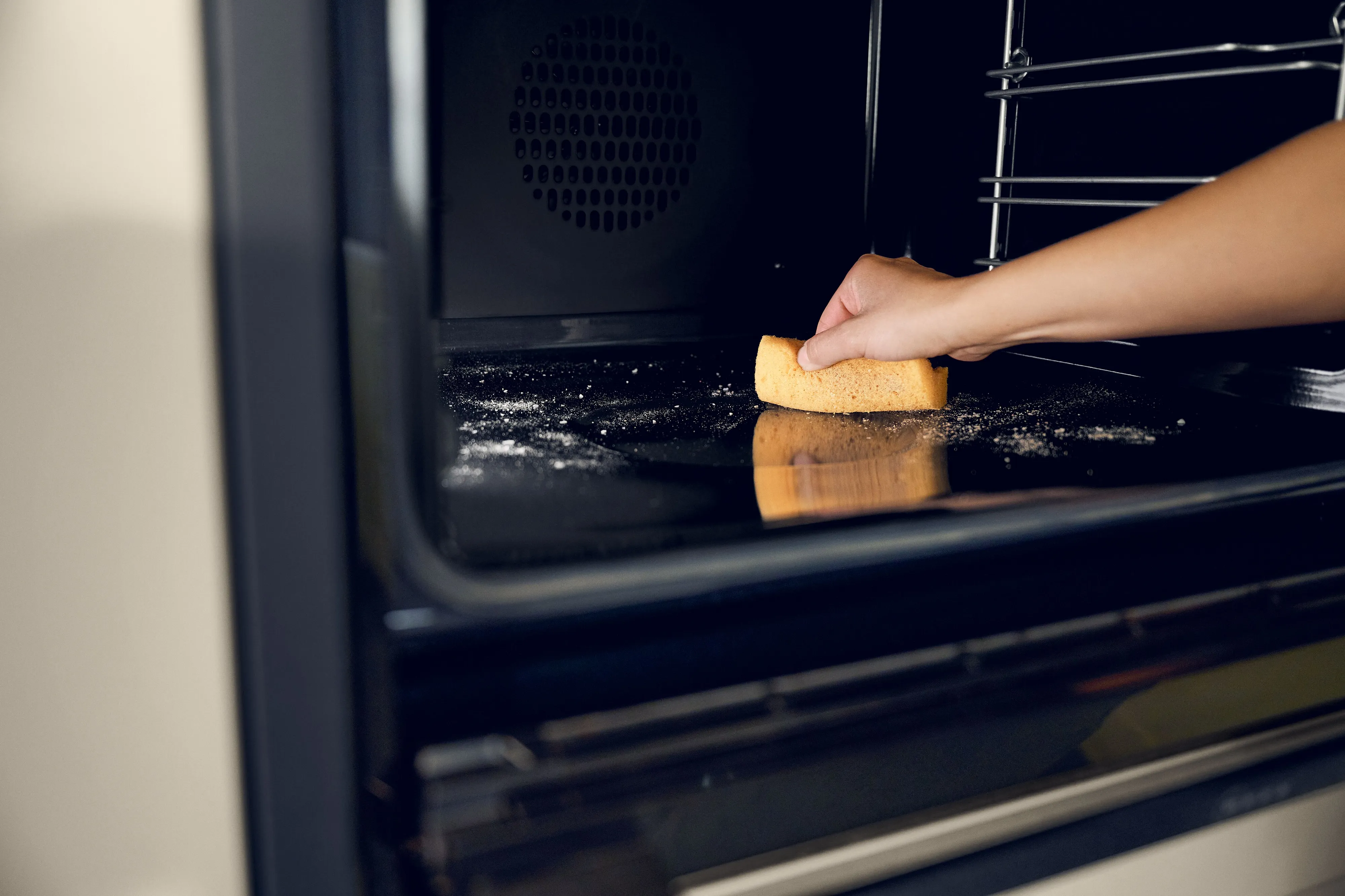 Cleaning the interior of a NEFF oven with a sponge.