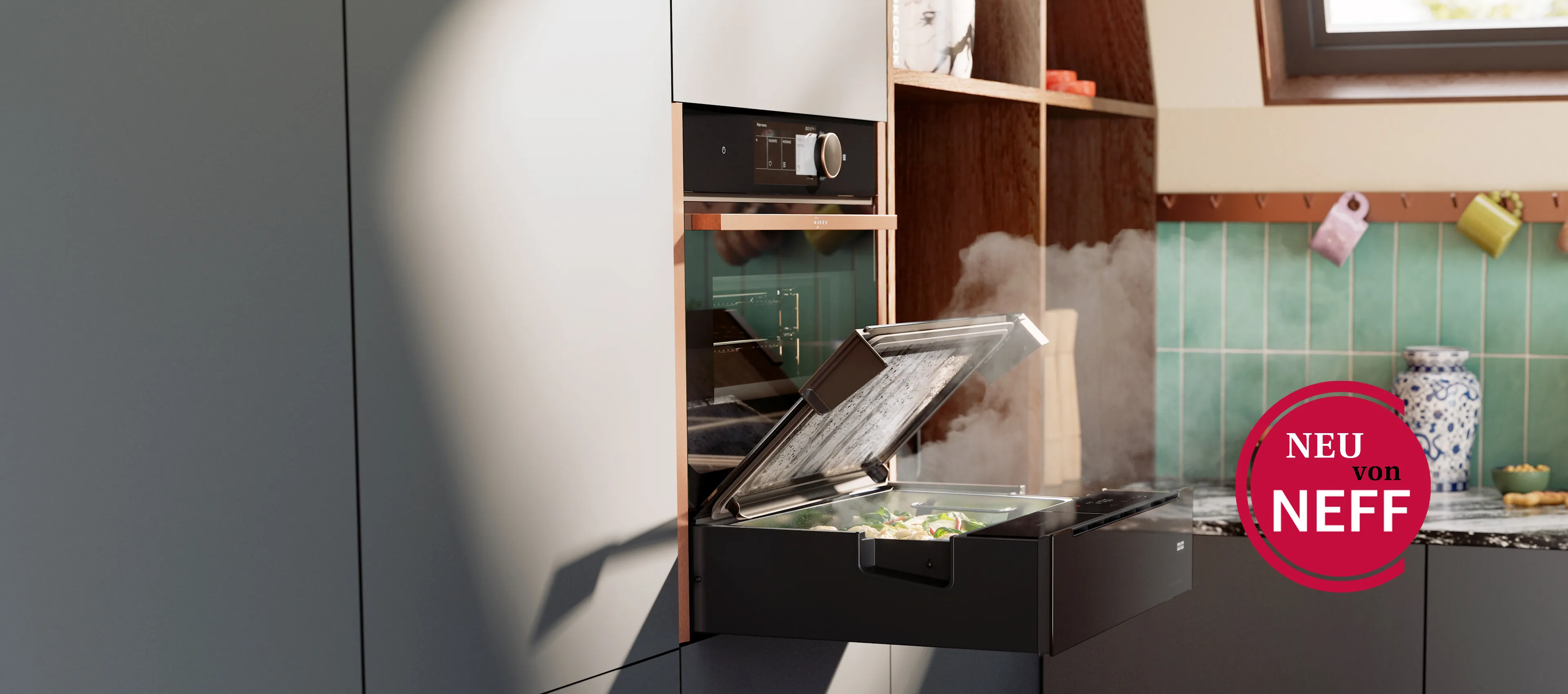 NEFF Dampf-Schublade in moderner Küche – platzsparend unter einem Backofen eingebaut, mit geöffnetem Glasdeckel und aufsteigendem Dampf beim Garen von frischem Gemüse.