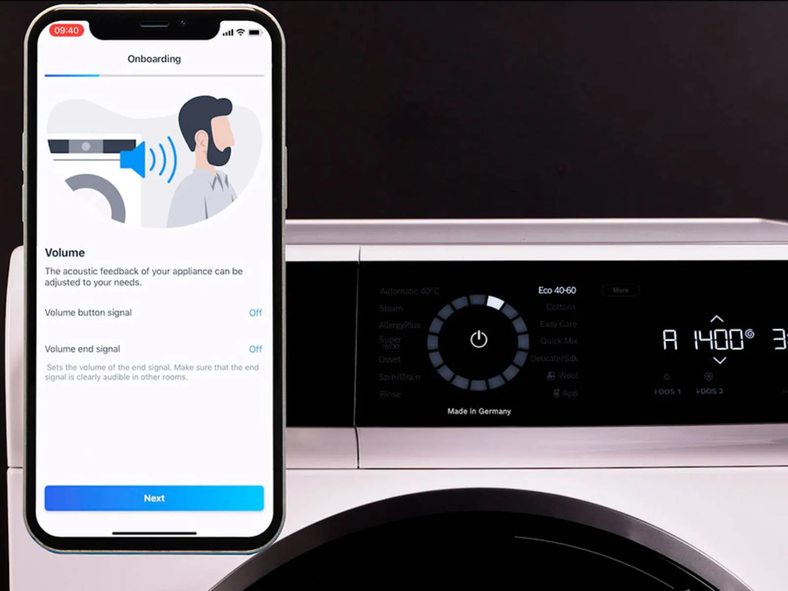Lähikuva pyykinpesukoneen paneelista. Vieressä puhelin, jonka näytöllä näkyy Home Connect -sovellus.