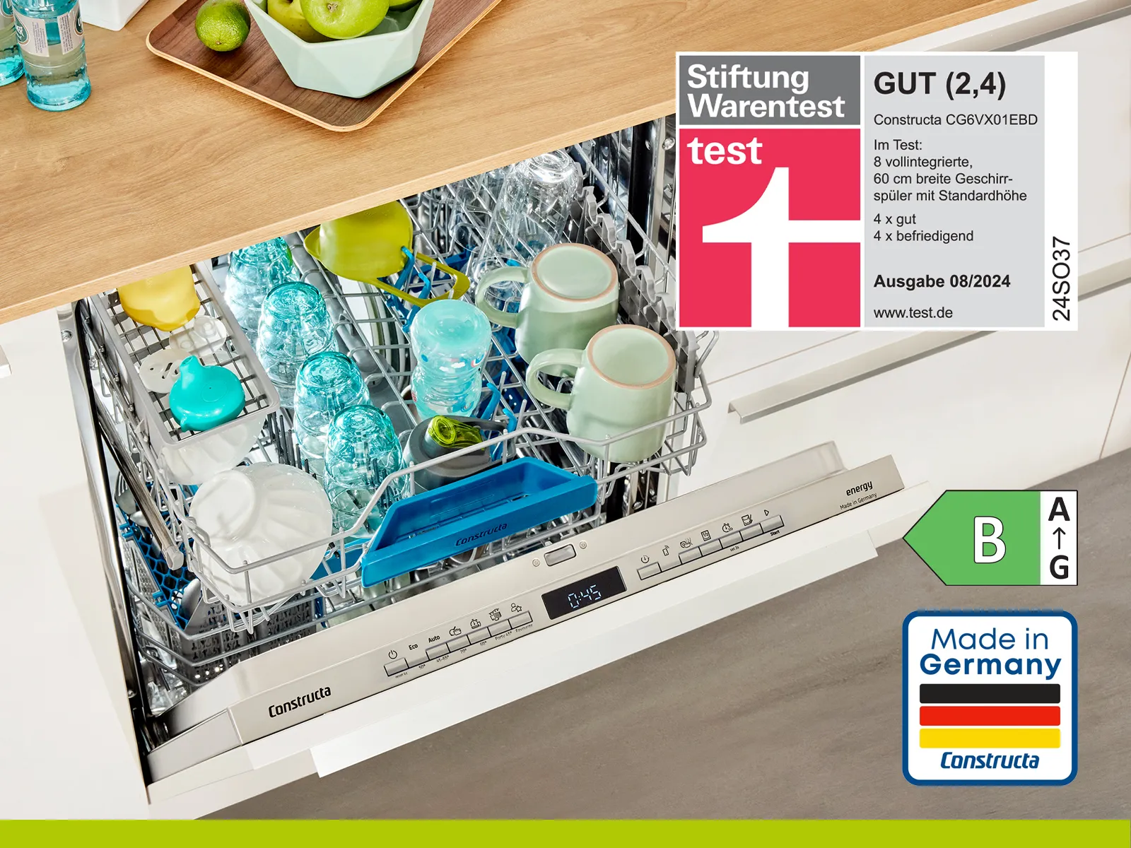 Constructa Geschirrspüler mit Geschirr und Tassen im oberen Korb. Stiftung Warentest Label und "Made in Germany" Logo.